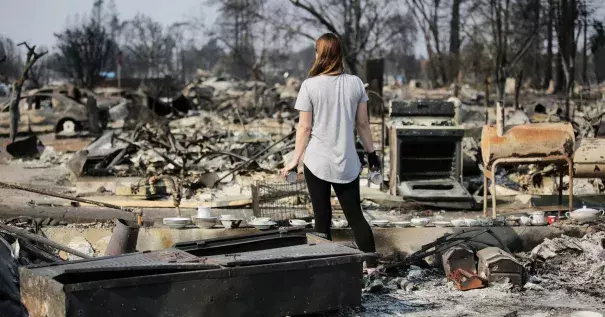 A woman looks out at the destruction caused by the Tubbs fire while holding items of emotional importance salvaged from her childhood home in the Coffey Park neighborhood on October 15, 2017 in Santa Rosa, California. Photo: Getty Images