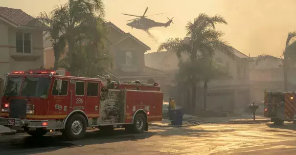 A helicopter dropped water onto a burning hillside in the Porter Ranch neighborhood. Credit: Kyle Grillot, The New York Times