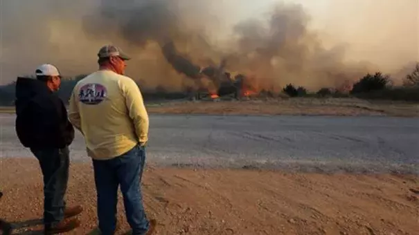 Jeff Clark and Roger Van Rankin watch the fire east of Lake City, Kan., Wednesday, March 23, 2016. Photo: AP
