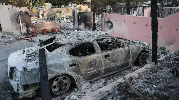 The remains of a destroyed car stand infront of a destroyed home in the aftermath of the Holiday Fire on July 7, 2018 in Goleta, California. Credit: Mario Tama, Getty Images