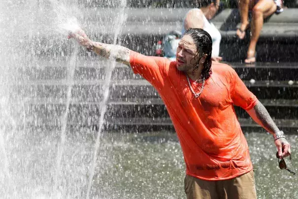 A man cools off himself in a fountain during a heat wave in New York City on July 23, 2016. Photo: Eduardo Munoz / Reuters