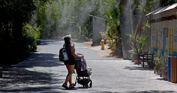 A visitor to the Phoenix Zoo walked through misting water on Tuesday. Credit: Matt York, Associated Press