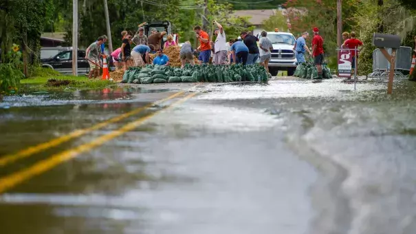 Volunteers pitched in to help residents fill sand bags against flooding from the Vermilion River in Lafayette, La. Photo: Scott Clause, Associated Press