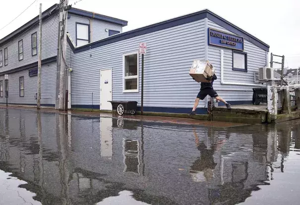 A FedEx delivery man jumps over pooling water on Portland Pier during the king tide. Tides are caused by the gravitational pull of the moon and this week's supermoon was closer to Earth than it has been in 68 years. Photo: Brianna Soukup