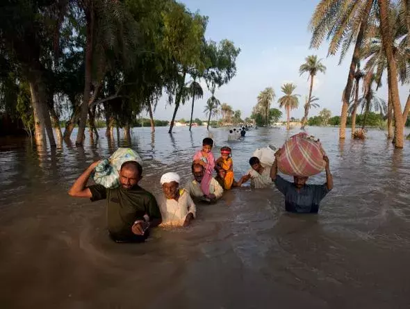 A family leaves flooded Baseera, Pakistan, this week. Photo: Adrees Latif, Reuters