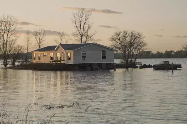 A home is surrounded by floodwaters in Bartlett, Iowa. Credit: Nati HarnikAP