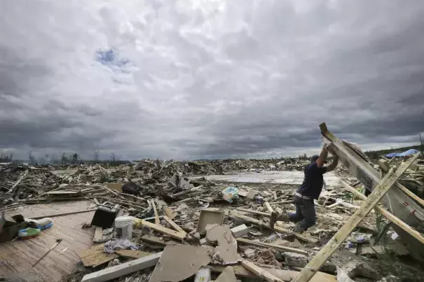 In this April 30, 2014, file photo, Dustin Shaw lifts debris as he searches through what is left of his sister's house at Parkwood Meadows neighborhood after a tornado in Vilonia, Ark. A new study finds that tornado activity is generally shifting eastward to areas just east of the Mississippi River that are more vulnerable such as Mississippi, Arkansas and Tennessee. And it's going down in Oklahoma, Kansas and Texas. Photo: Danny Johnston, AP