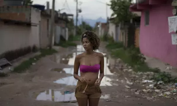 amires da Costa, 16, who is four months pregnant, stands in a street with standing flood water next to her home in the Parque Sao Bento shantytown of Rio de Janeiro, Brazil on 29 January 2016. Photo: Leo Correa, AP