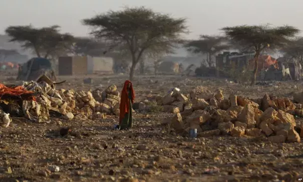 A Somali woman walks through a camp of people displaced from their homes elsewhere in the country by the drought, shortly after dawn in Qardho, Somalia, March 9, 2017. Photo: AP