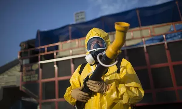 A health worker stands in the Sambadrome as he sprays insecticide to combat the Aedes aegypti mosquitoes that transmit the Zika virus, in Rio de Janeiro, Brazil. Photo: Leo Correa, AP