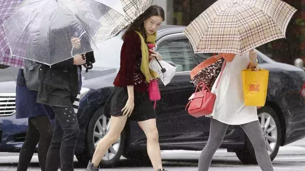 Pedestrians make their way through a street in Tokyo while a powerful typhoon approaches Tokyo, Oct. 6, 2014. Photo: AP/Kyodo News 