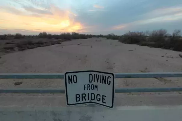 A sign from wetter times warns people not to dive from a bridge over the Kern River, which has been dried up by water diversion projects and little rain, on February 4, 2014 in Bakersfield, California. Photo: Associated Press