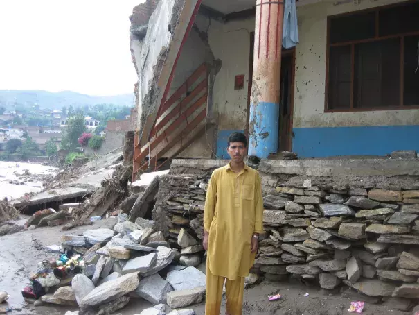 Fazal Mowla stands in front of his collapsed house in Faizabad village in Swat. Photo: Oxfam International