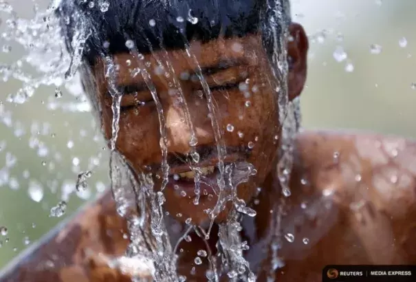 A worker takes a bath from the water of a bore pump on a hot summer day during a heat wave in Gurgao, India, on May 29, 2015. Photo: Anindito Mukherjee, Reuters