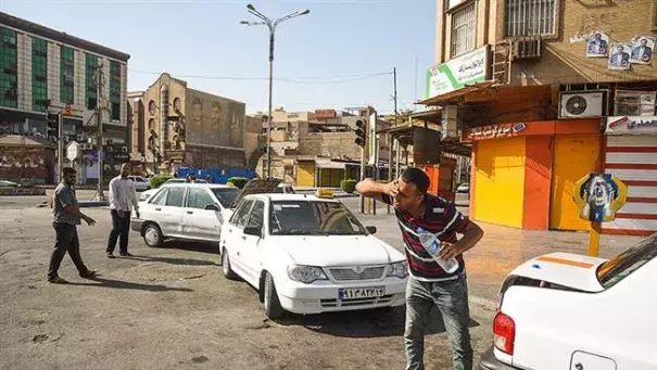 This file photo shows a man trying to lower his body temperature by pouring drinking water on his face, in the Iranian city of Ahvaz, in southern Khuzestan Province. Photo: PressTV