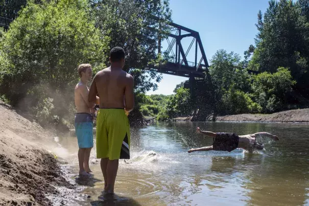 As his friends chat on the bank, Kamoni Taylor, 22, of Centralia, jumps into the Chehalis River with his dog, Bentley, 3, on Monday afternoon off of Highway 603 in Adna. Photo: Pete Caster, Chronline