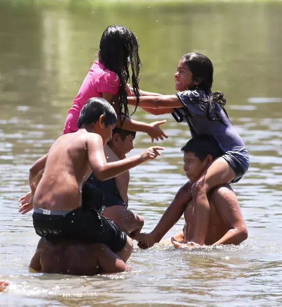 Members of the Amaya family square off with a "chicken fight" in the cool waters of Hart Park Lake Thursday. Photo: Felix Adamo, The Californian