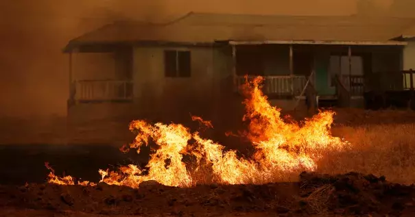 Grass burns in front of a home during the Detwiler fire in California, on July 19. Photo: Stephen Lam, Reuters