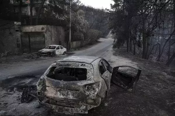 Burnt automobile line the streets following a wildfire east of Athens, on July 25. Credit: Yorgos Karahalis, Bloomberg