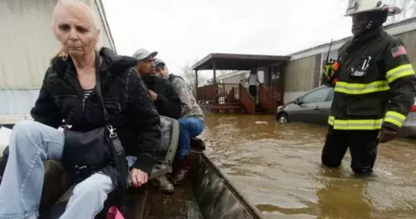 Marcie Traylor rides in a boat after being rescued from the Pecan Valley Mobile Home community that was flooded because of Wednesday rains. Bossier Firefighter Cameron LaCoure was out helping as well as neighbors who volunteered their boats for rescues. Photo: Henrietta Wildsmith/The Times