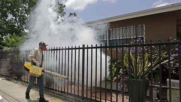 A Miami-Dade County mosquito control worker sprays around a home in the Wynwood area of Miami on Monday, Aug. 1, 2016. Photo: Alan Diaz