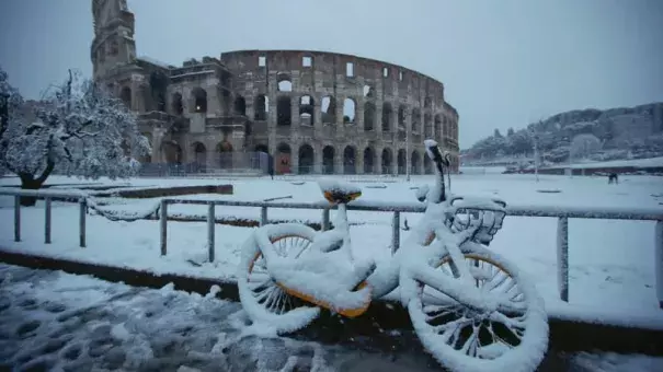 A bicycle is parked in front the ancient Colosseum during a snowfall in Rome. Photo: AP
