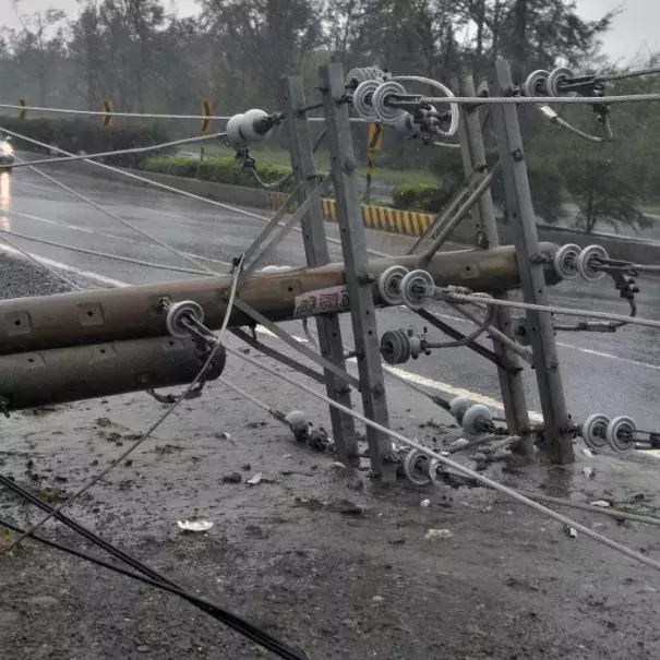 Cars drive past collapsed power lines, as super typhoon Meranti skirts Pingtung county in southern Taiwan. Photo: ABC News