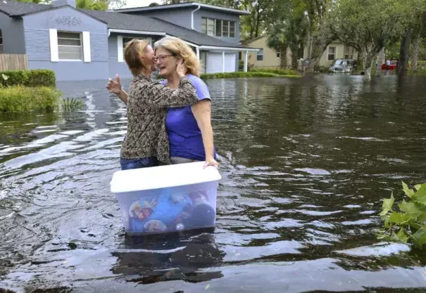 Charlotte Glaze gives Donna Lamb a teary hug as she floats out to some of belongings in teh floodwaters from the Ortega River in Jacksonville, Florida, Monday, Sept 11, 2017, after Hurricane Irma passed through the area. Photo: Dede Smith, The Florida Times-Union via AP