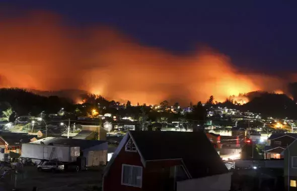 A wildfire approaches Chile's Dichato community, Monday, Jan. 30, 2017, where firefighters are working to keep the flames away from the estimated 800 homes. Families continue to be evacuated as firefighters battle the fires that are consuming a part of southern Chile. Photo: Esteban Felix, AP