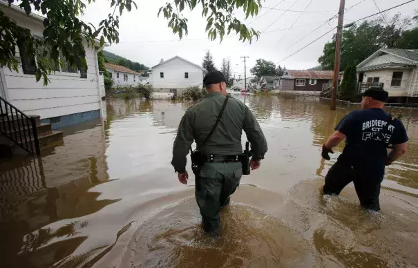 In this June 25, 2016, file photo, West Virginia State Trooper C.S. Hartman, left, and Bridgeport W. Va., fireman, Ryan Moran, wade through flooded streets as they search homes in Rainelle. A rainstorm that seemed no big deal at first turned into a catastrophe for the small town in West Virginia, trapping dozens of people whose screams would echo all night. Photo: Steve Helber, AP