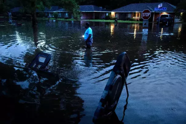 Tracy Thornton walks to his house through a flooded neighborhood August 15, 2016 in Baton Rouge, Louisiana.Floods ravaged the US state of Louisiana. Photo: Brendan Smialowski, AFP, Getty Images