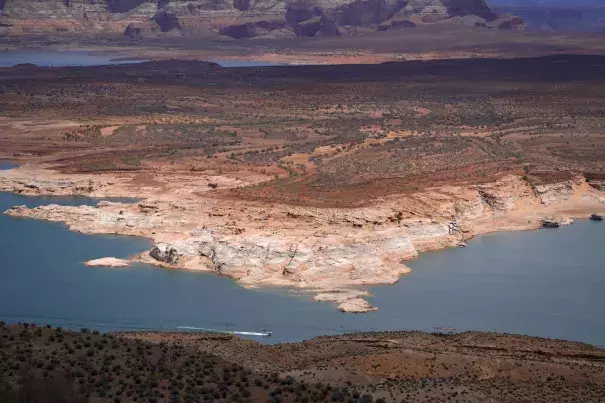 A boat moves along Wahweap Bay along the Upper Colorado River Basin, Wednesday, June 9, 2021, at the Utah and Arizona border near Wahweap, Ariz. (Credit: Ross D. Franklin/AP Photo)