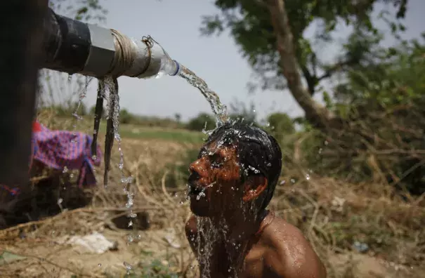 An Indian man takes bath under the tap of a water tanker on a hot day in Ahmadabad, India, Thursday, May 21, 2015. Photo: AP