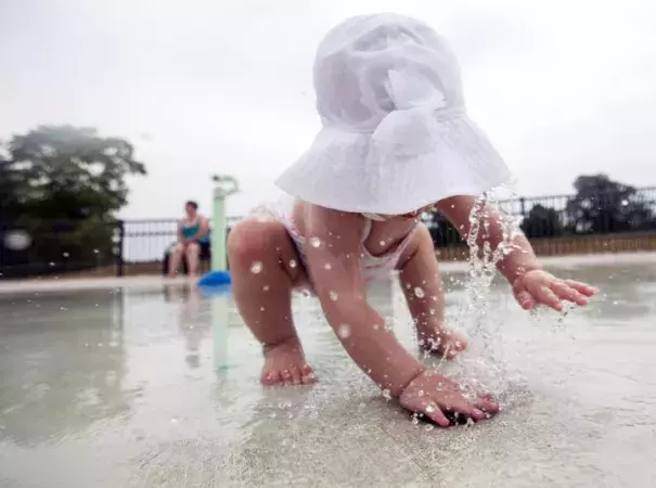 Ella Roberts, 1, of Saginaw Township uses her hands Wednesday, July 6, to cover a water spout at Celebration Square Splash Park in Saginaw. Photo: Josie Norris, The Saginaw News via AP