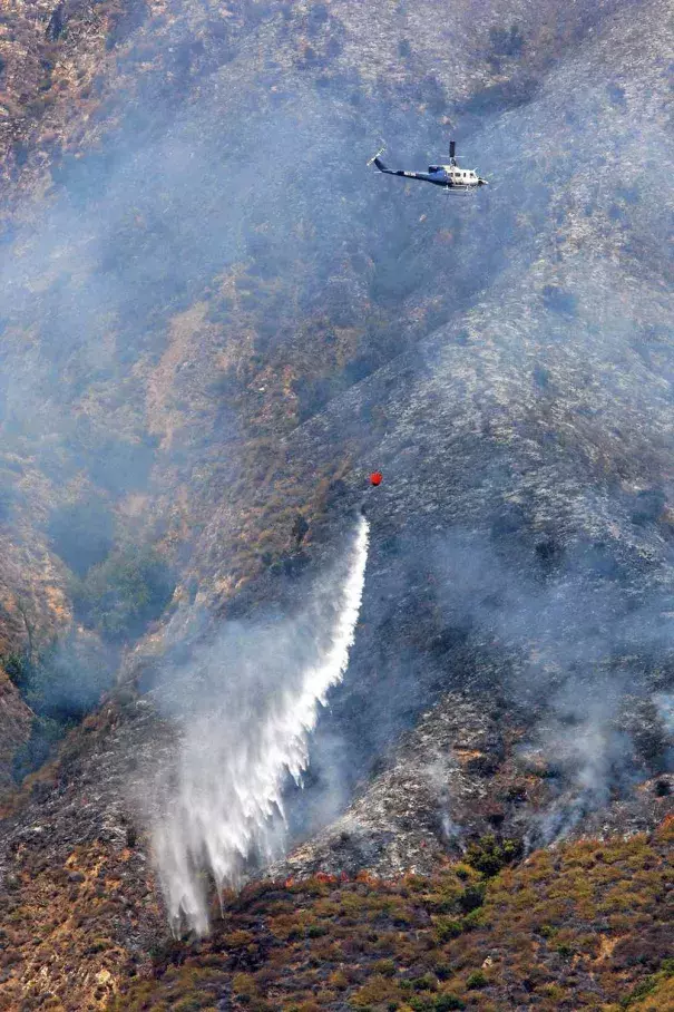 A helicopter makes a water drop on the Soberanes Fire as it burns on the west slope of Mount Manuel in Pfeiffer Big Sur State Park on Tuesday. Photo: Vern Fisher / Monterey Herald