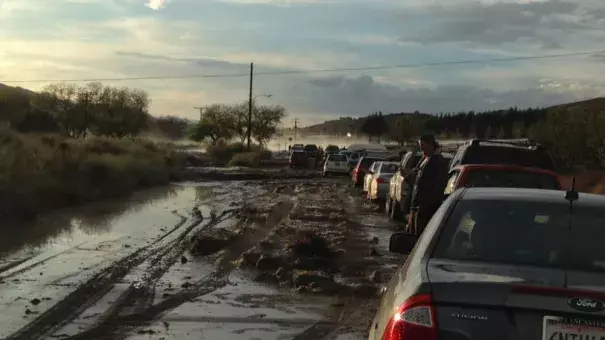 Cars on a road in Lake Hughes, California are stopped because of flooding, with some stuck in the mud in the distance. Flash flooding sent water, mud and rocks rushing across Interstate 5 north of Los Angeles on Thursday, stranding hundreds of vehicles and closing the major north-south thoroughfare. Photo: Robert Rocha , AP