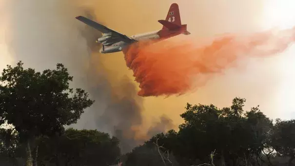 A plane drops a load of retardant on a wildfire north of Lompoc, California, Monday, June 29, 2015. Photo: Associated Press