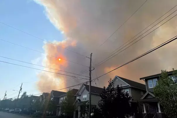 Smoke from the Tantallon wildfire rises over houses in nearby Bedford, Nova Scotia, Canada, on Sunday. (Credit: Eric Martyn/Reuters)