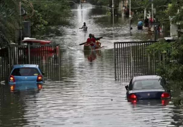 People travel on a boat as they move to safer places through a flooded road in Chennai, India, December 2, 2015. REUTERS/STRINGER