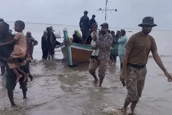 In this picture released by Pakistan's Sindh Rangers, paramilitary soldiers help to evacuate people from a village due to Cyclone Biparjoy approaching, at a costal area of Thatta district, in Pakistan's Sindh province, Tuesday, June 13, 2023. Pakistan's army and civil authorities are planning to evacuate 80,000 people to safety along the country's southern coast, and thousands in neighboring India sought shelter ahead of Cyclone Biparjoy, officials said. (Credit: Pakistan's Sindh Rangers via AP)