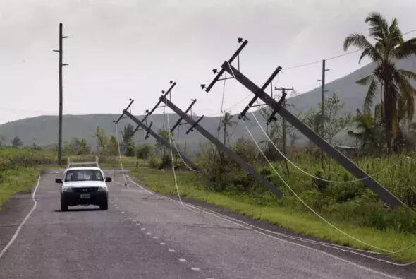 A car drives along Kings Road near Lautoka, Fiji, Wednesday, Feb. 24, 2016, where power poles lean over after cyclone Winston ripped through the island nation. The cyclone tore through Fiji over the weekend with winds that reached 177 miles (285 kilometers) per hour, making it the strongest storm in Fiji's recorded history. Photo: Brett Phibbs, AP