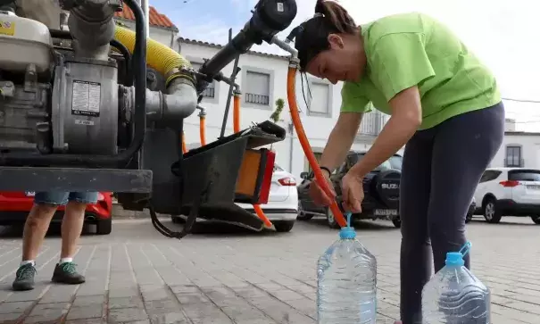 A woman fills bottles with drinking water from a truck in Alcaracejos, Spain, on 27 April after the local reservoir nearly dried out. (Credit: Reuters)