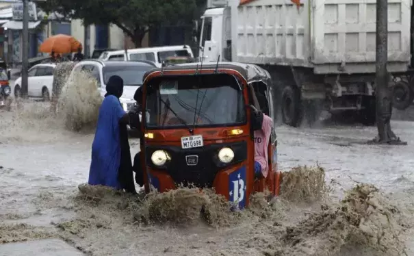 A woman disembarks from a rickshaw taxi in the flooded KM5 street following heavy rains in Mogadishu, Somalia November 8, 2023 (Credit: REUTERS/Feisal Omar)