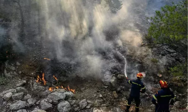 Firefighters try to control a wildfire in New Peramos, near Athens, Greece. (Credit: Louisa Gouliamaki/AFP/Getty Images)