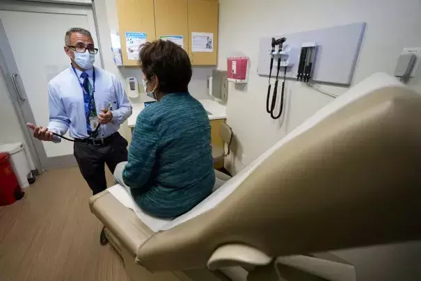 Nurse practitioner Anthony Carano speaks with a patient at the Mountain Park Health Center, Thursday, March 30, 2023, in Phoenix. As heat waves fueled by climate change arrive earlier, grow more intense and last longer, people over 60 who are more vulnerable to high temperatures are increasingly at risk of dying from heat-related causes. Heat related deaths are challenging community health systems, utility companies, apartment managers and local governments to better protect older people when temperatures s