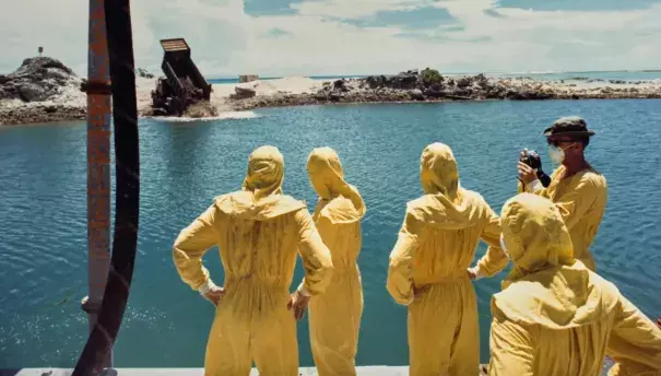 U.S. military officers watch nuclear waste being dumped on Runit Island in the Marshall Islands. (Credit: Department of Defense via Grist)