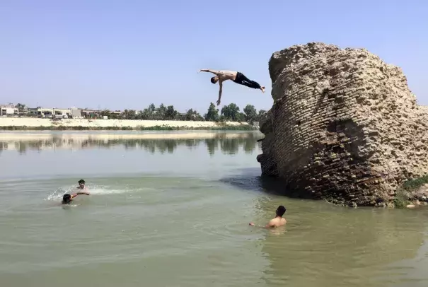 Iraqis jump off the ruins of an old building into the Tigris River to beat the heat in Baghdad on Aug. 1. The temperature in Baghdad reached 117 degrees. Photo: Ali Abdul Hassan/AP