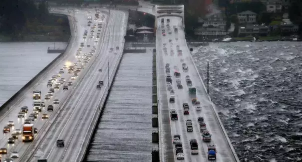 Eastbound traffic lanes, right, on Interstate 90 are dampened by wind-driven waves from the south as the floating bridge calms Lake Washington to the north, left, Tuesday, Nov. 17, 2015, in Seattle. Image credit: AP Photo/Elaine Thompson.