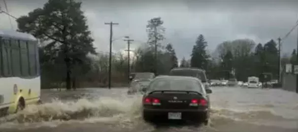 Drivers cautiously proceed through Johnson Creek floodwaters on SE Foster Road near 111th Avenue. Heavy rain caused flooding and landslides in the Portland area on Monday, December 7, 2015.