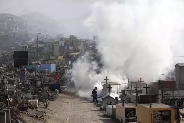 A health worker sprays fumigation vapour to stem the spread of dengue virus at the Nueva Esperanza cemetery in Lima, Peru, June 1, 2022. (Credit: REUTERS/Sebastian Castaneda/File Photo)